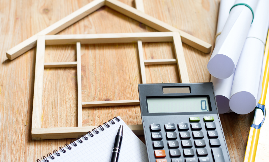 Casa in legno e calcolatrice per interventi di ristrutturazione